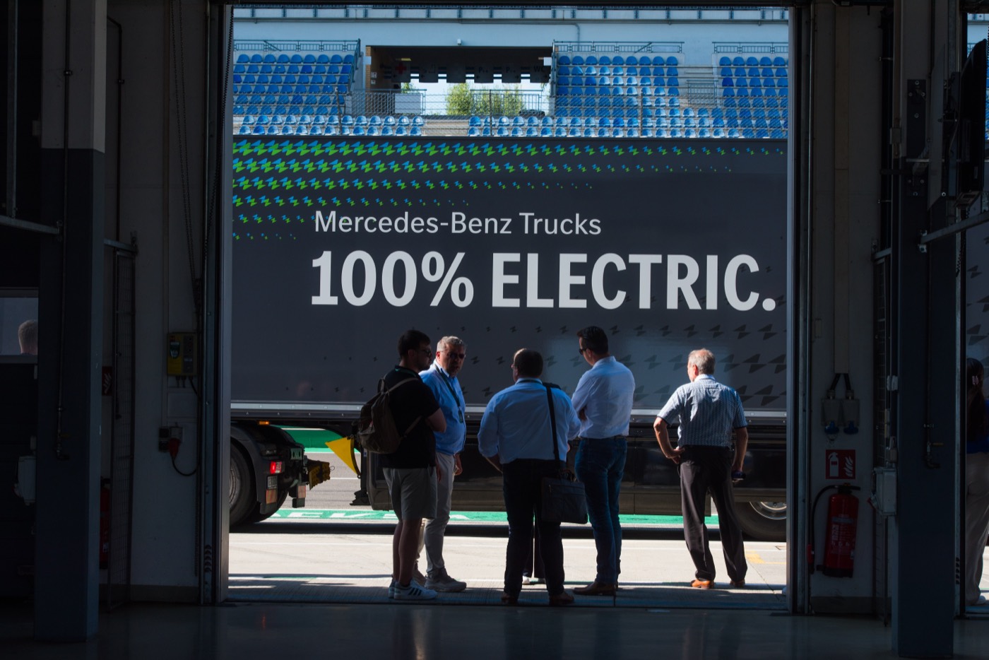 Besucher in einer Halle vor einem Mercedes-Benz-Lkw mit der Aufschrift „100% Electric“