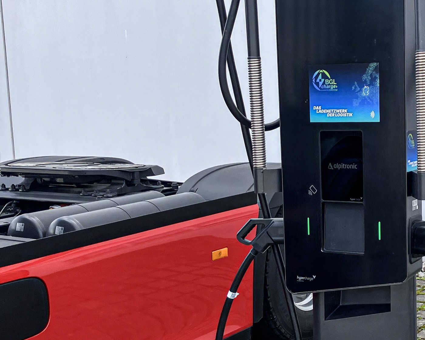 Alpitronic-Schnellladesäule mit BGL-Charge-Display neben einer roten Zugmaschine